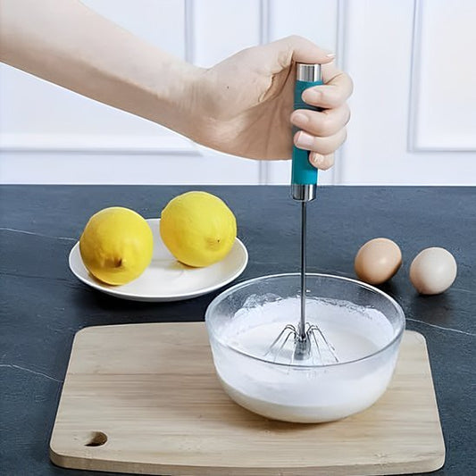 batteur manuel manche vert en train de monter des blancs en neige