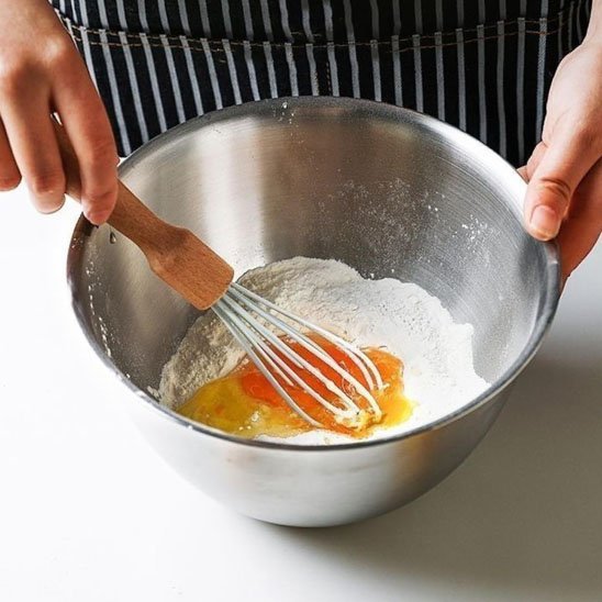 Cul de poule inox dedans puit de farine avec des oeufs