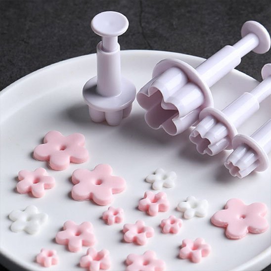 Emporte pieces​ sur plaque blanche fleur en pate a sucre