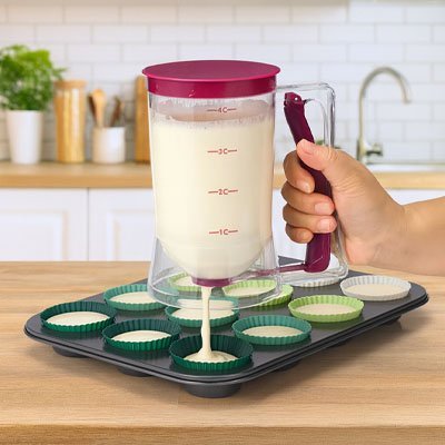 entonnoir a piston en train de verser la pate dans moules muffin