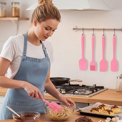 Femme qui melange une pate avec spatule cuisine rose
