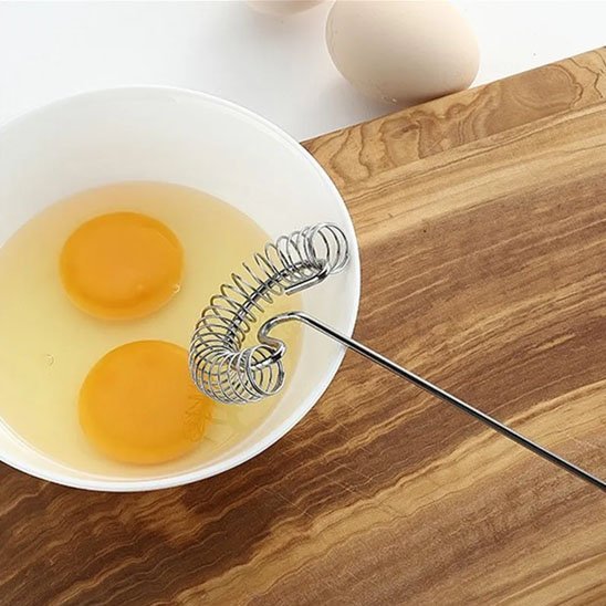 Fouet au dessus du bol avec des oeufs