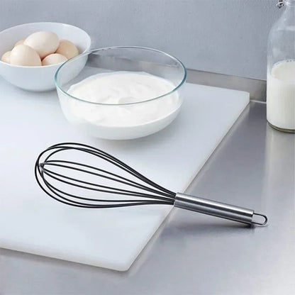 fouet inox sur plan travail avec oeuf et farine