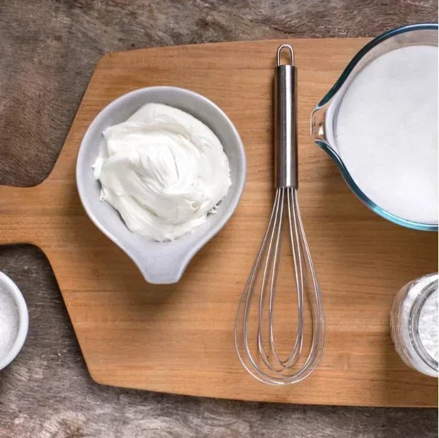 fouet inox sur planche bois sucre et blanc neige