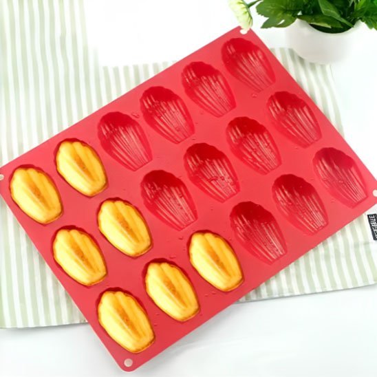 Moule à madeleine rouge silicone 18 empreintes avec 7 madeleines cuites dans le moule