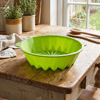 moule gateau en silicone vert sur  table en vieux bois