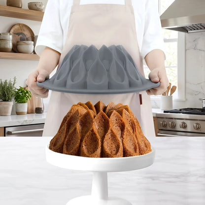 moule gateau slicone gris dans les mains en train de retirer le gateau cuit