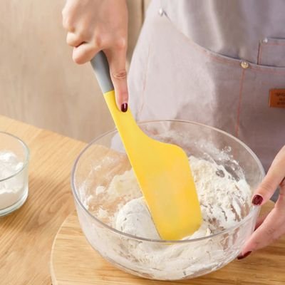 Spatule jaune qui mélange une pate