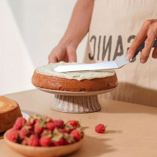 spatule premium qui lisse un gateau sur un presentoir a gateau