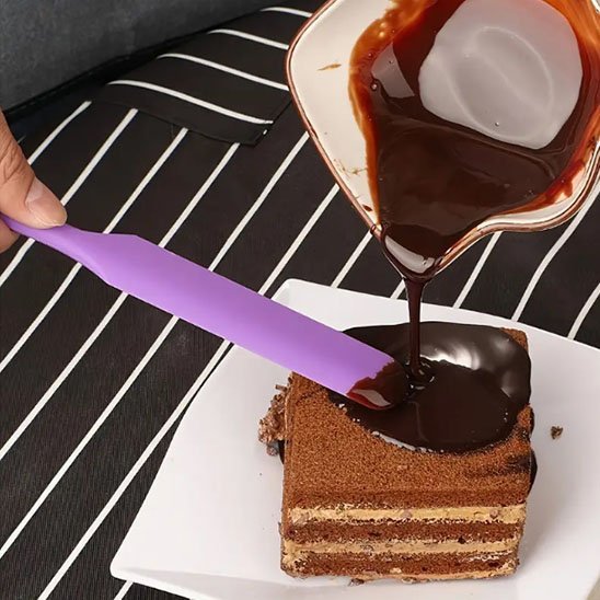 Spatule qui lisse du chocolat sur gateau