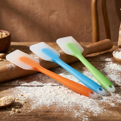 spatule silicone bleu vert orange sur plan travail  avec de la farine