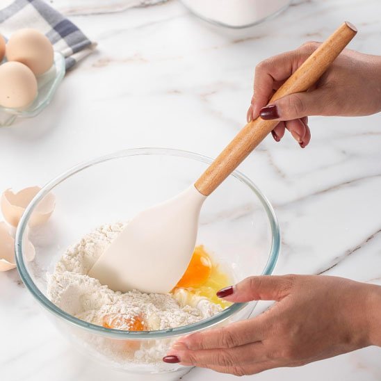 une femme melange avec une spatule en silicone