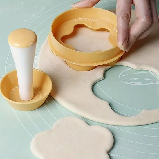 une personne faisant une empreinte avec emporte piece pate sur tapis silicone
